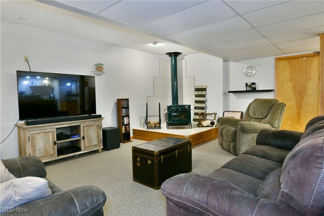 Carpeted living room with a wood stove | Image 38