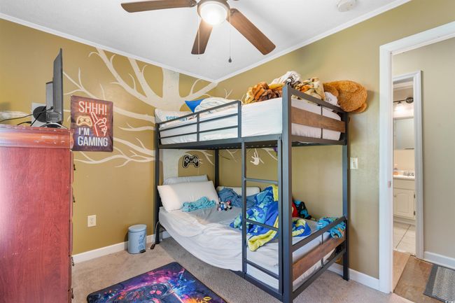 Bedroom featuring carpet, crown molding, and a ceiling fan | Image 23