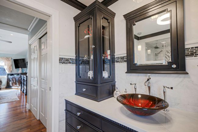 Bathroom with a sink, crown molding, and wood finished floors | Image 20