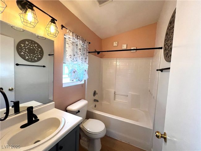 Full bathroom featuring visible vents, toilet, vanity, lofted ceiling, and shower / bathing tub combination | Image 17
