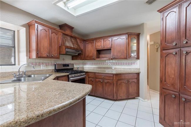 Kitchen, tasteful backsplash, light countertops, and light tile patterned floors. | Image 8