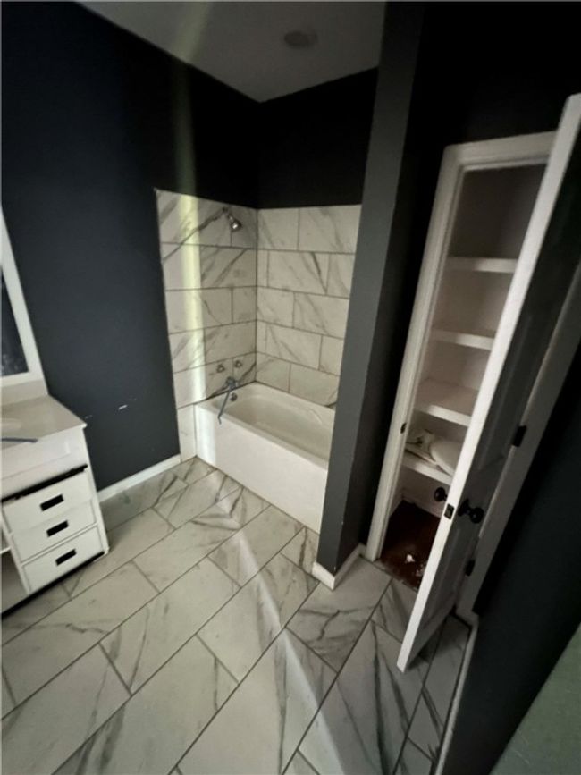 Full bath featuring marble look tiles, vanity, and shower / bathtub combination | Image 9