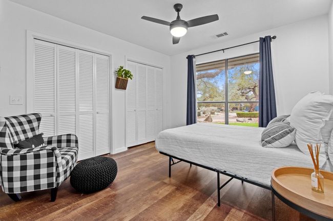 Bedroom with multiple closets, hardwood / wood-style floors, and ceiling fan | Image 21