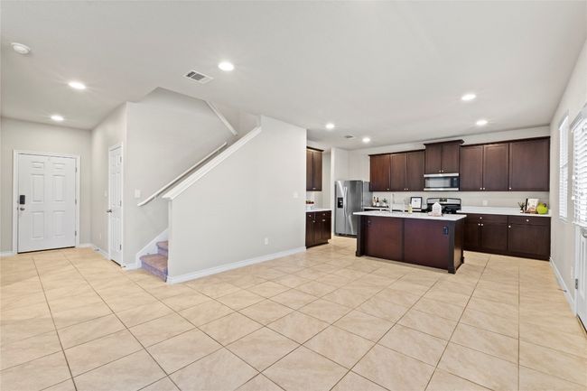 Kitchen featuring dark brown cabinets, recessed lighting, light countertops, and stainless appliances | Image 4