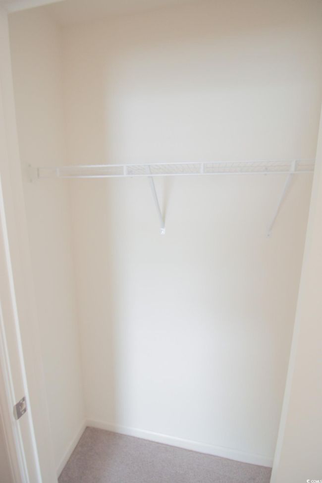 Walk in closet featuring light colored carpet | Image 22