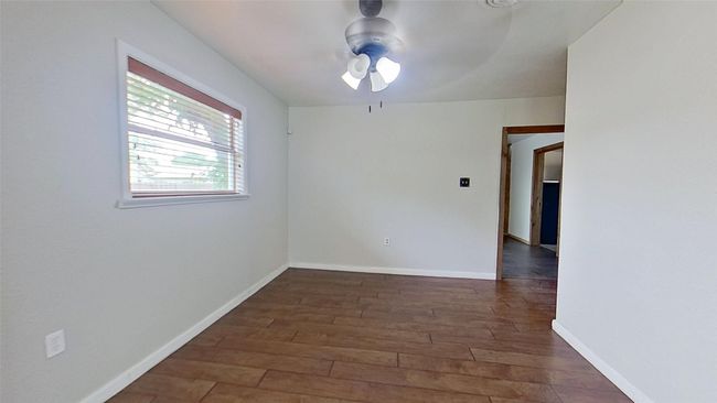 Empty room featuring wood finished floors, a ceiling fan, and baseboards | Image 11