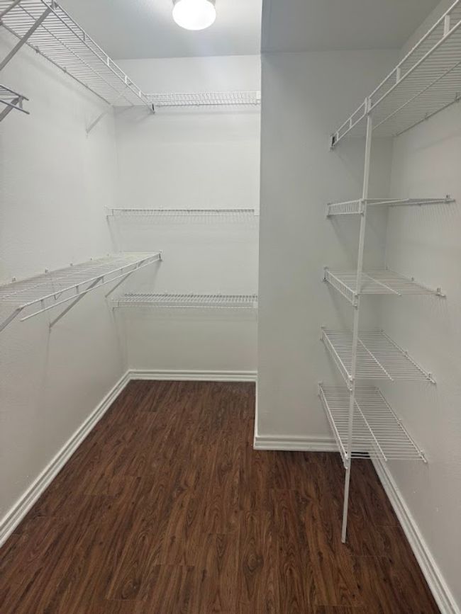 Walk in closet featuring wood finished floors | Image 7