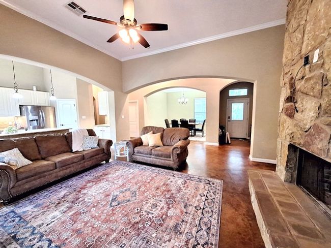 Living room featuring ceiling fan, visible vents, arched walkways, and ornamental molding | Image 6