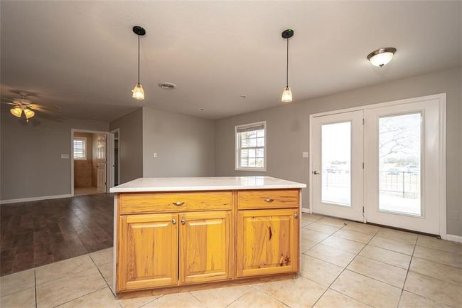 Kitchen featuring light tile patterned floors, light countertops, and decorative light fixtures | Image 19