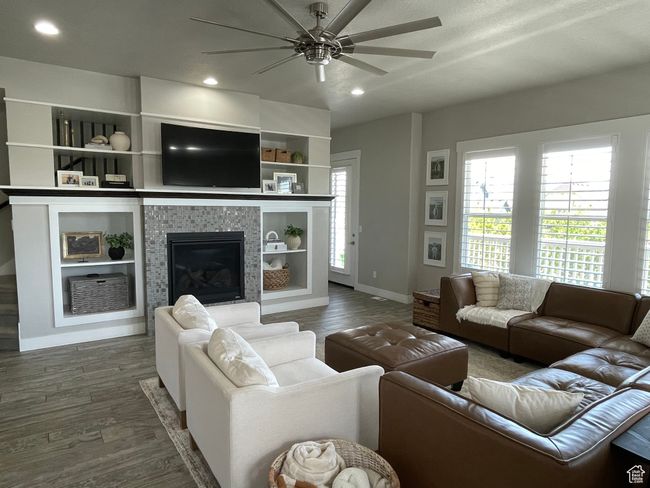 Living room featuring plenty of natural light, a ceiling fan, fireplace and entertainment nooks | Image 23