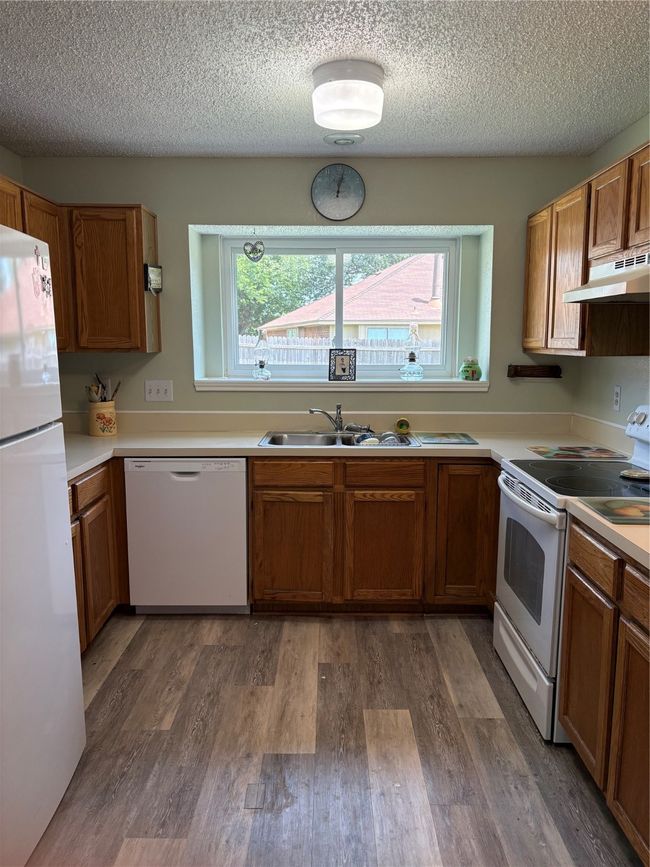 Kitchen with dishwasher, stove, refrigerator, ventilation hood, and wood finished floors | Image 6