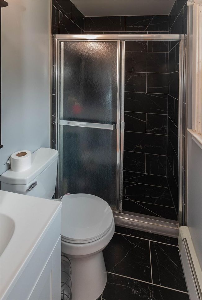 Updated primary bathroom with new tile stall shower, new vanity, toilet and porcelain floors | Image 11