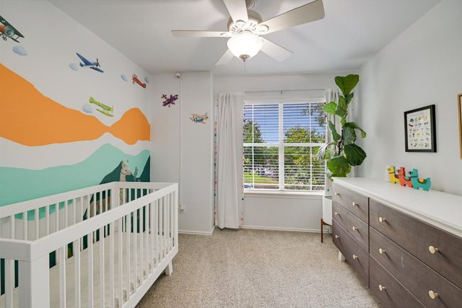 Bedroom with a crib, light colored carpet, and a ceiling fan | Image 17
