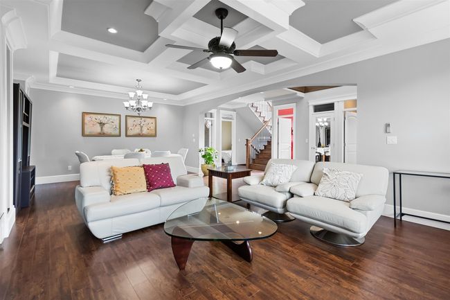 Living area with stairway, baseboards, hardwood / wood-style flooring, a ceiling fan, and arched walkways | Image 6