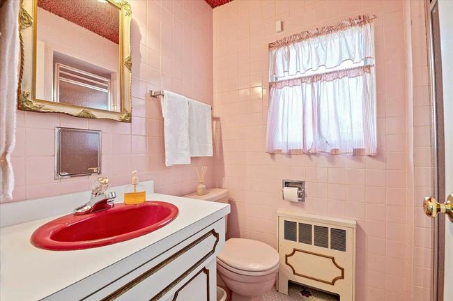 Bathroom featuring radiator, tile walls, vanity, and a shower | Image 14