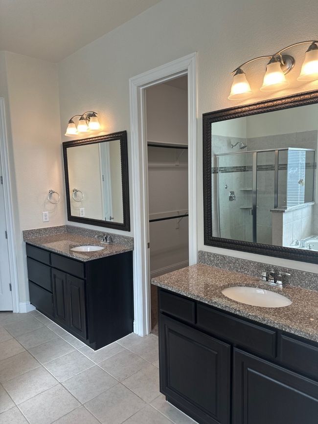Bathroom with a stall shower, a sink, and tile patterned floors | Image 15