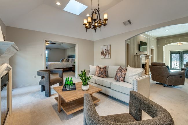 Living area featuring arched walkways, light carpet, a fireplace, and visible vents | Image 21