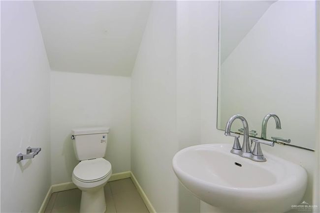 Half bath featuring baseboards, a sink, toilet, and tile patterned floors | Image 10