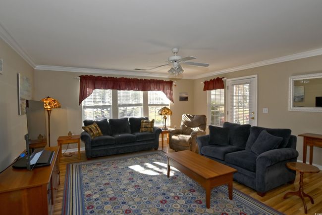 Living room with ceiling fan, wood-type flooring, and ornamental molding | Image 8