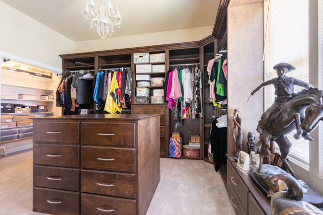 Walk in closet with light carpet and a chandelier | Image 15