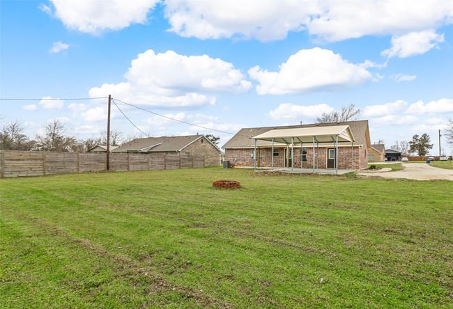 View of yard featuring a fenced backyard, a fire pit, and a patio | Image 20