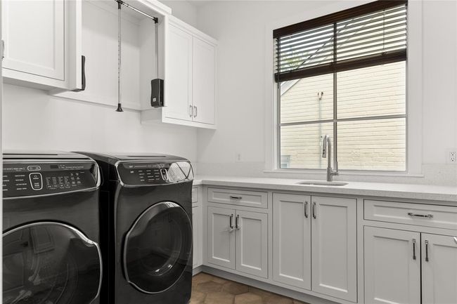 Convenient laundry room up w/ deep utility sink & plenty of storage space. Gas & electric connections; custom cabinets to accommodate large machines. | Image 44