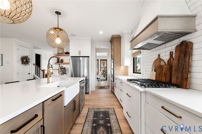 Kitchen featuring light wood-style flooring, light countertops, pendant lighting, appliances with stainless steel finishes, and recessed lighting | Image 15