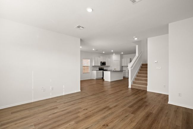 Unfurnished living room with recessed lighting, visible vents, stairway, light wood-style floors, and baseboards | Image 18