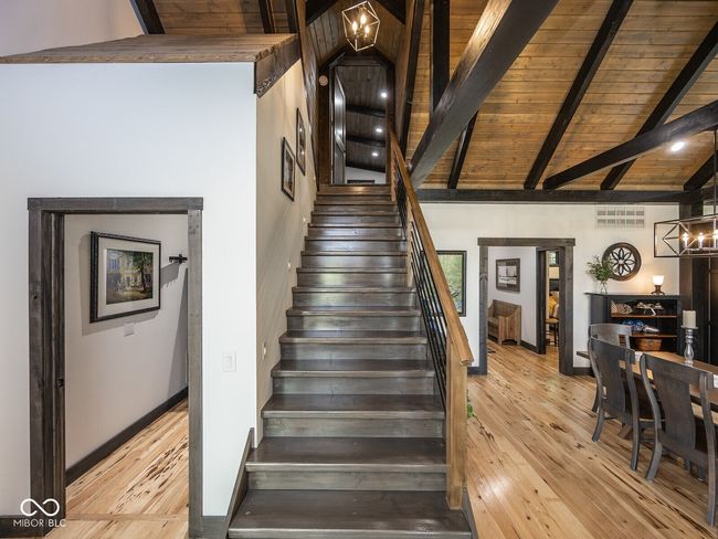 stairs with hardwood / wood-style flooring, baseboards, wood ceiling with exposed beams, and high vaulted ceiling | Image 29