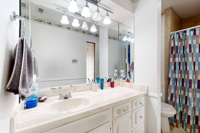 Bathroom with visible vents, toilet, a shower with shower curtain, and vanity | Image 19