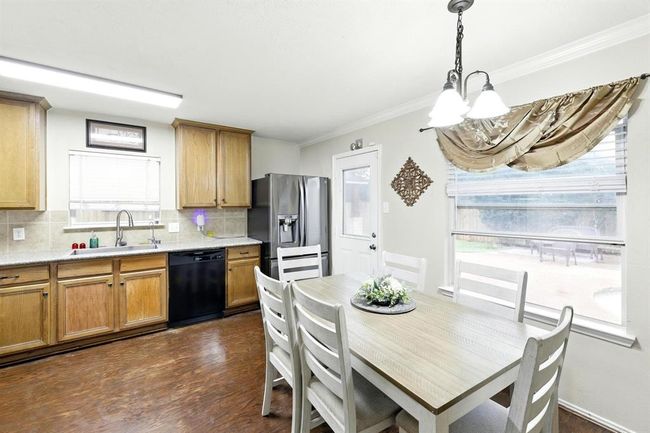 Bright and airy eat-in kitchen with large windows, backyard views, and direct patio access, perfect for casual dining and entertaining. | Image 6