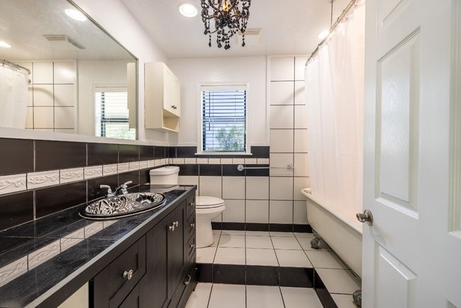Full bath with vanity, a shower with curtain, tile patterned flooring, toilet, and tile walls | Image 15