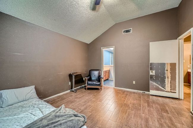 Living area featuring wood finished floors, vaulted ceiling, and a textured ceiling | Image 16