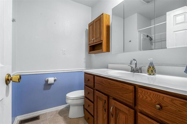 Bathroom with baseboards, vanity, toilet, and a shower | Image 52