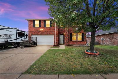 View of front facade featuring cooling unit, a garage, and a lawn | Image 1