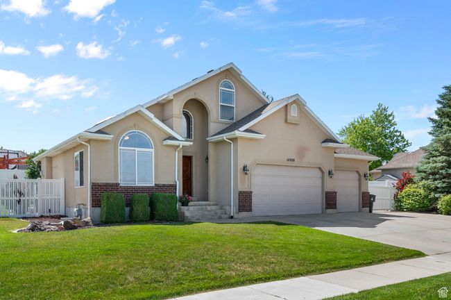 View of front facade featuring concrete driveway, stucco and brick siding, and a garage | Image 4