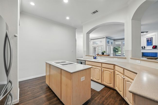 Kitchen featuring stainless steel appliances, arched walkways, dark wood-style flooring, light brown cabinets, and recessed lighting | Image 8