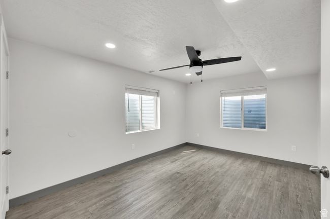 Spare room featuring baseboards, a ceiling fan, wood finished floors, and a textured ceiling | Image 23