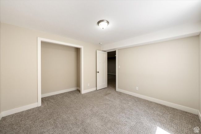 Unfurnished bedroom with baseboards and light colored carpet | Image 46