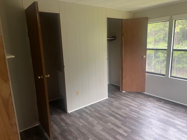 Empty room with ornamental molding, dark wood finished floors, and baseboards | Image 11