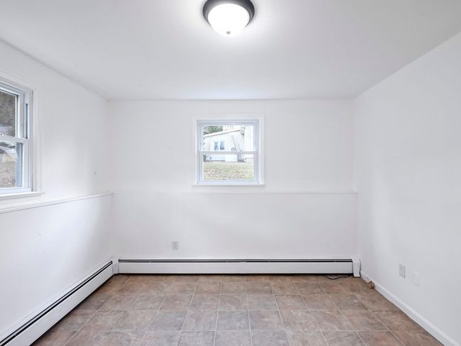 Unfurnished room with baseboard heating | Image 17