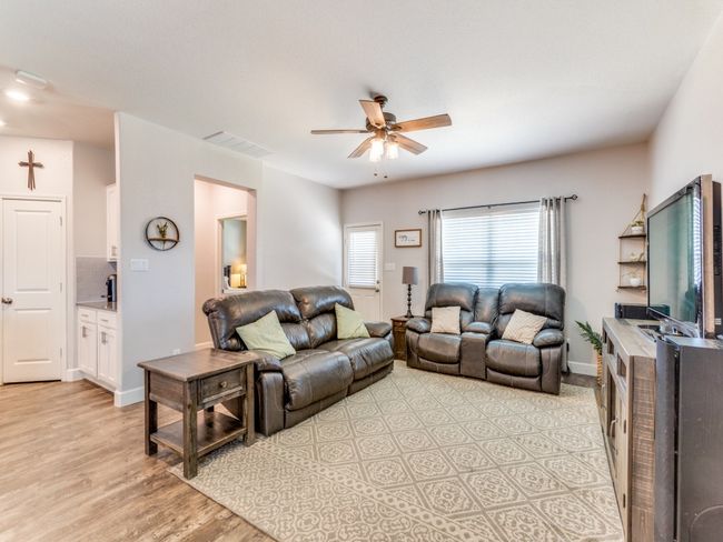Living area with ceiling fan and light wood finished floors | Image 4