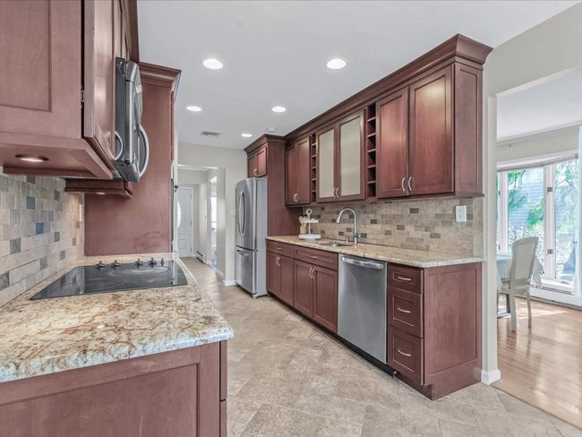 Kitchen featuring visible vents, light stone countertops, a sink, and stainless steel appliances | Image 10
