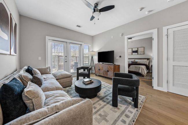 Living room with french doors, baseboards, light wood-style floors, and a ceiling fan | Image 16