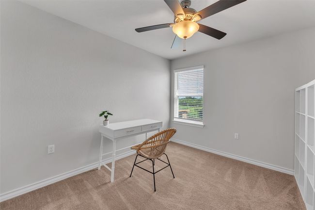 Office space with light colored carpet, baseboards, and a ceiling fan | Image 22
