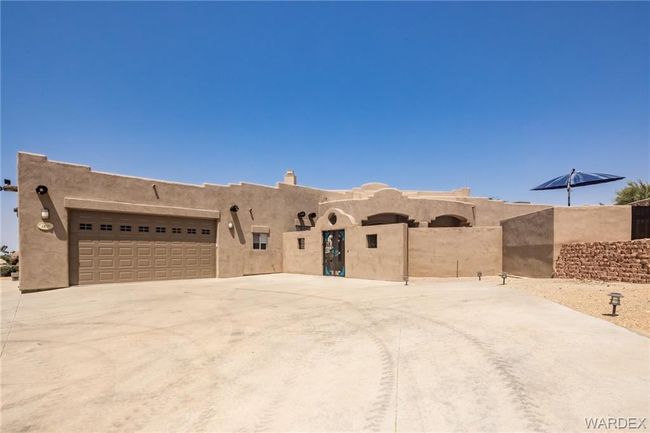 Adobe home featuring a garage, driveway, and stucco siding | Image 9