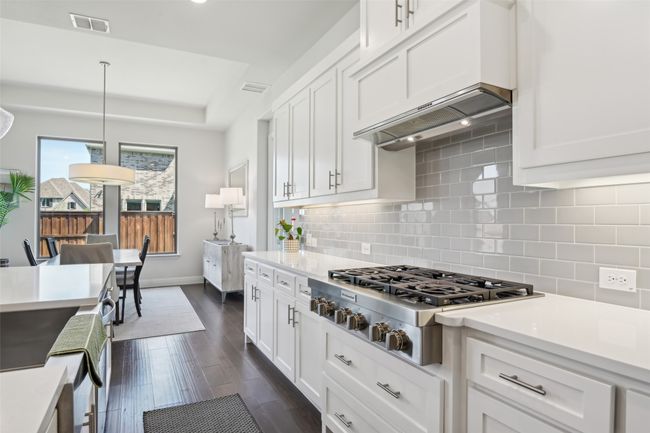 Kitchen featuring stainless steel gas cooktop, light countertops, white cabinetry, and recessed lighting | Image 13