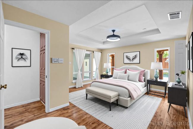 Primary Bedroom with a raised ceiling, wood finished floors, and baseboards | Image 17