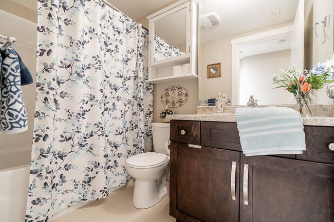 Bathroom with toilet, vanity, tile patterned floors, and shower / bath combo | Image 31