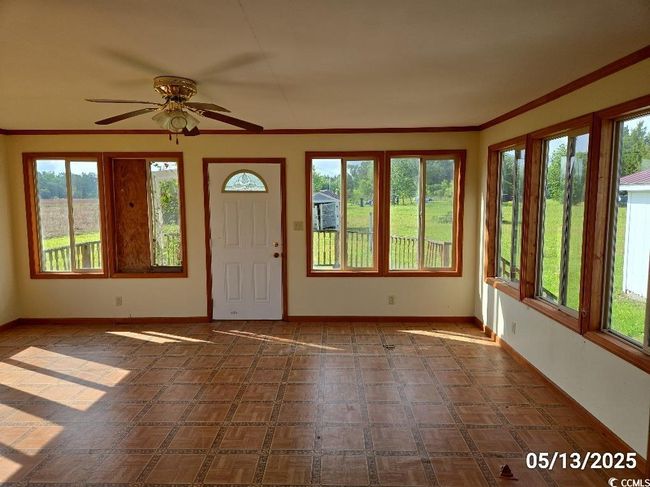 Entrance foyer featuring healthy amount of natural light, baseboards, a ceiling fan, and ornamental molding | Image 25